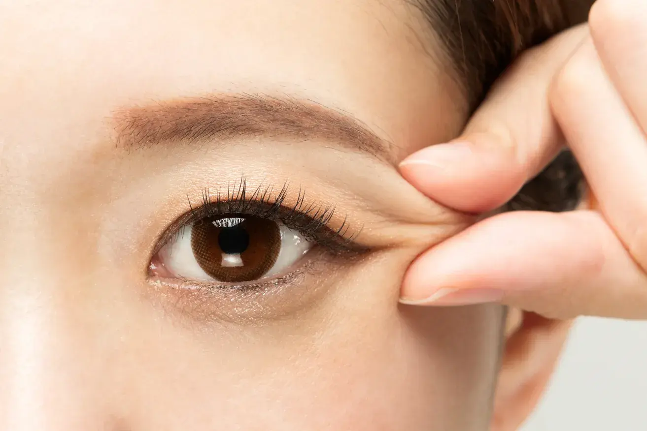 Woman gently pinching the corner of her eyelid