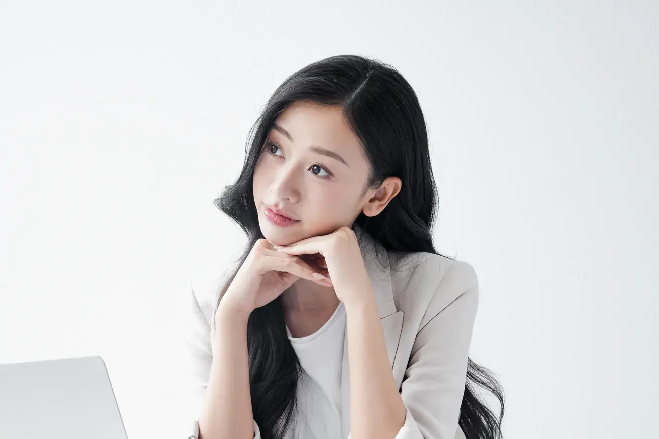 Woman thinking of questions before plastic surgery consultation