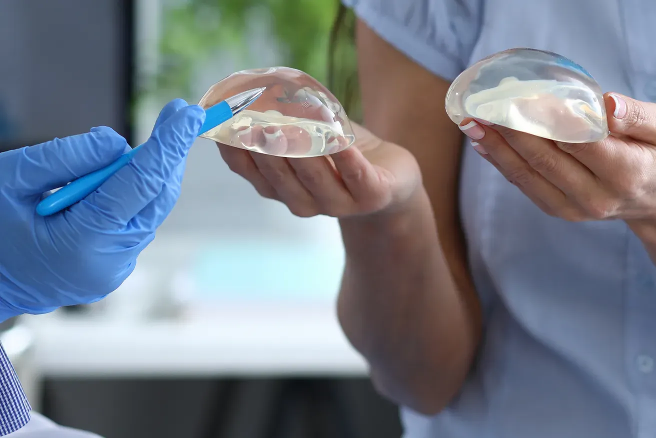 Breast lift surgeon explaining breast augmentation to patient using implants