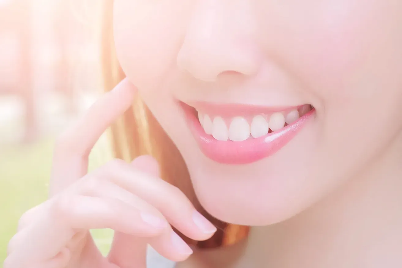 Close up of a smiling woman touching her jaw