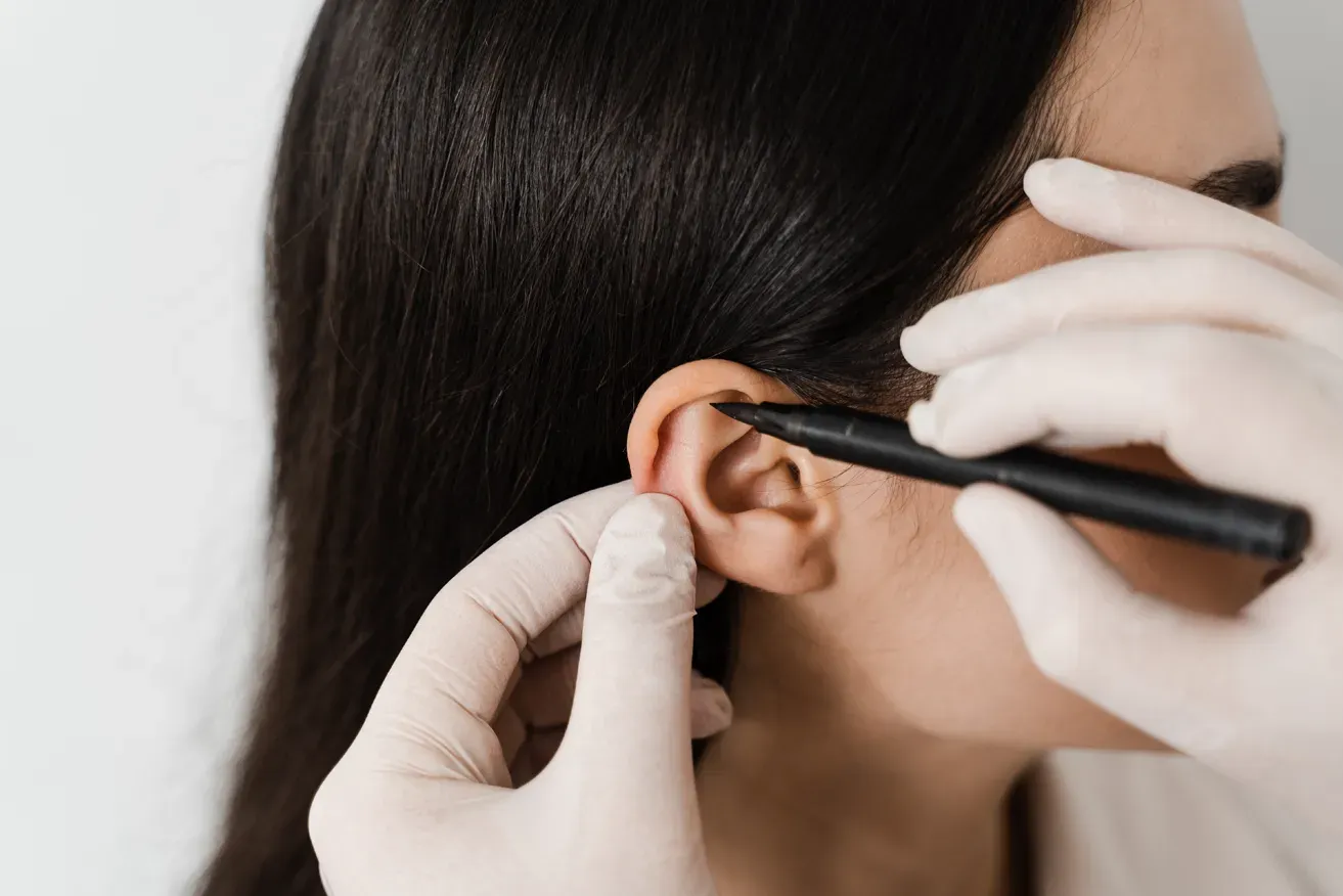 Plastic surgeon examining woman’s ears