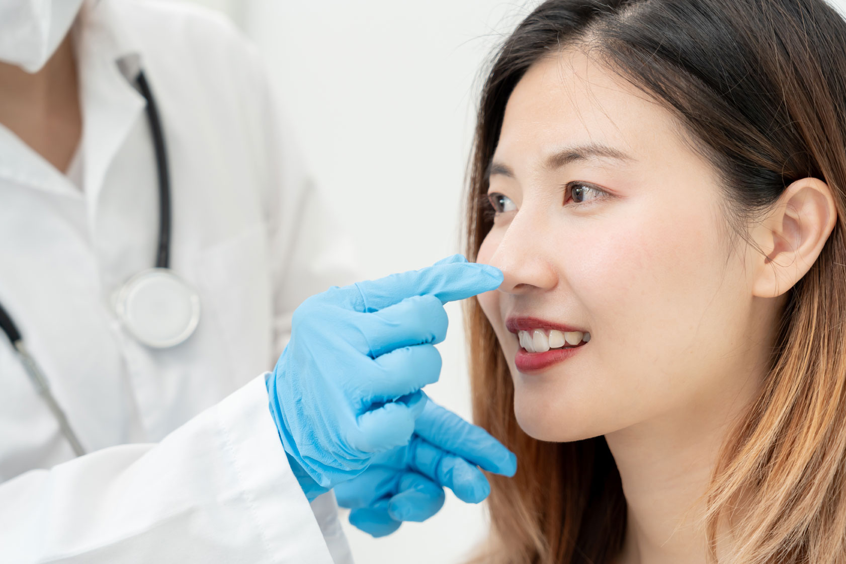Woman in rhinoplasty consultation with a plastic surgeon while discussing aesthetic 