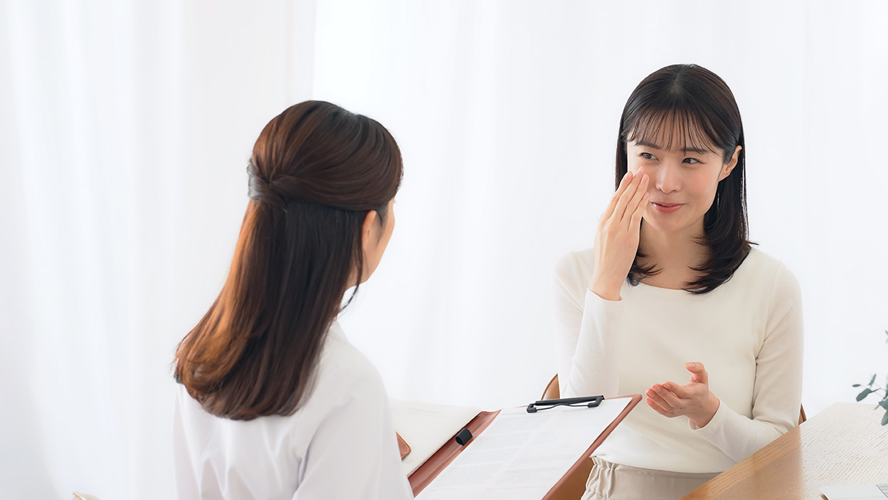 Woman speaking with a plastic surgeon during a consultation about her aesthetic concerns.