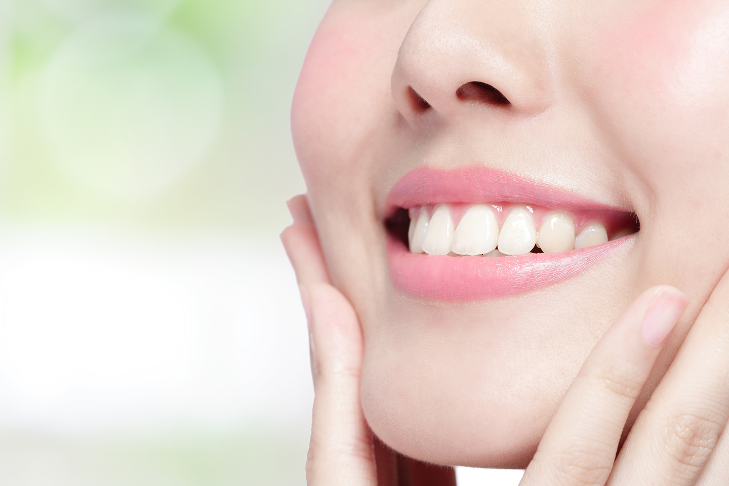 Close-up of a young woman’s face showing jawline and smile.