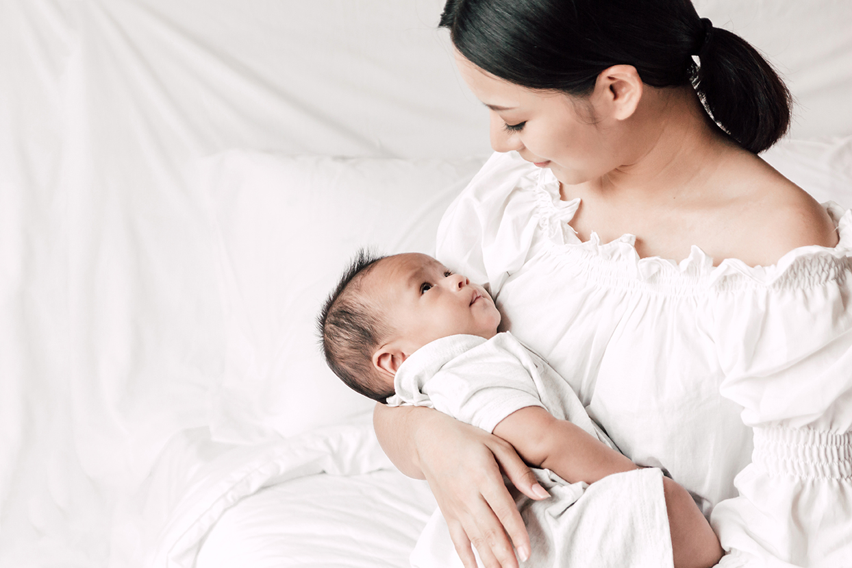 Mother holding her baby, representing post-pregnancy body changes.